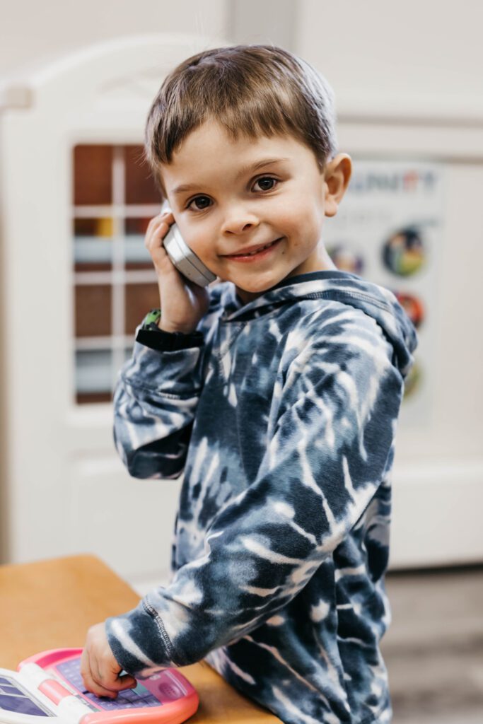 a boy holding a phone to his ear