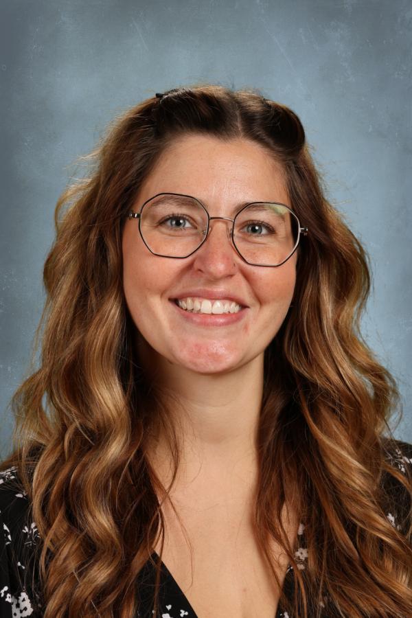 Portrait of a smiling woman with long brown hair and glasses