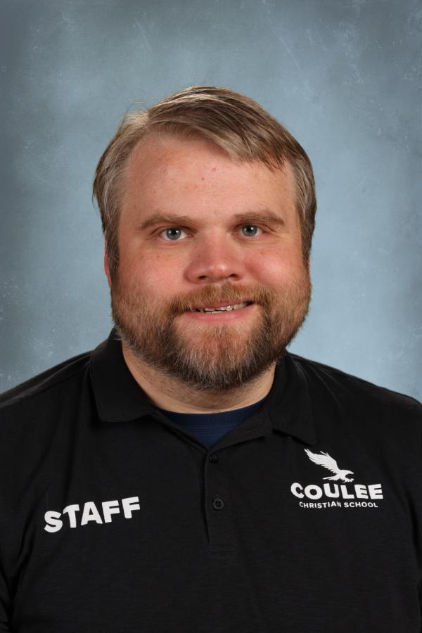 Staff member at Coulee Christian School wearing a black polo shirt with school logo.