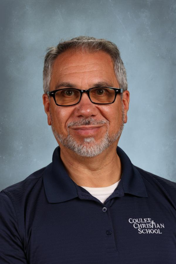 Man with glasses and beard wearing a navy polo shirt with "Coulee Christian School" logo.