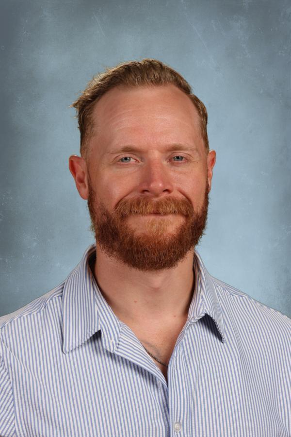 Man with red beard and blue eyes wearing a striped shirt
