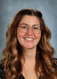 Portrait of a smiling woman with long brown hair and glasses