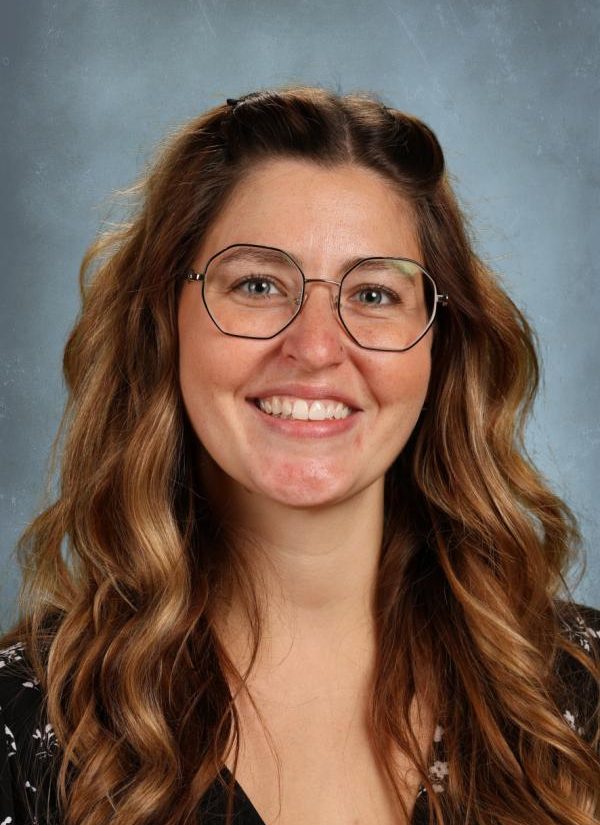 Portrait of a smiling woman with long brown hair and glasses