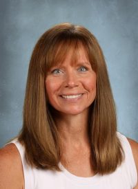 Middle-aged woman with brown hair and blue eyes smiling