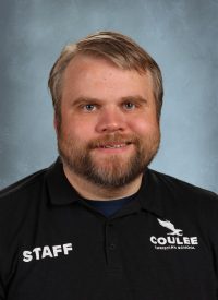 Staff member at Coulee Christian School wearing a black polo shirt with school logo.