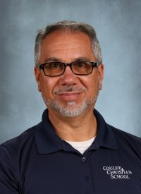 Man with glasses and beard wearing a navy polo shirt with "Coulee Christian School" logo.