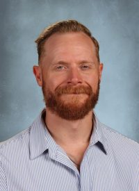 Man with red beard and blue eyes wearing a striped shirt